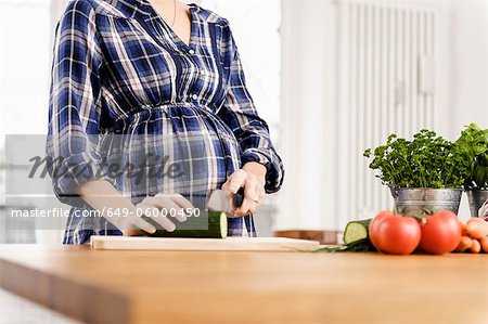 Pregnant woman chopping vegetables