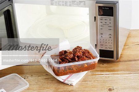 Woman heating leftovers in microwave