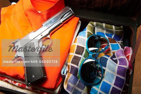 Gun and sunglasses in suitcase