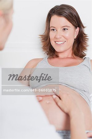 Doctor examining pregnant womans belly