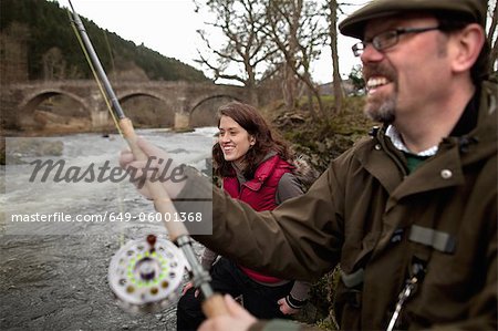 Couple fishing for salmon in river