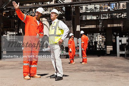 Workers talking at oil refinery