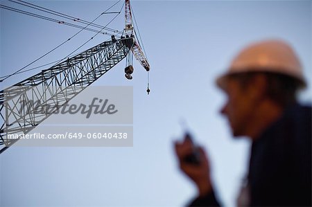 Crane over worker at oil refinery