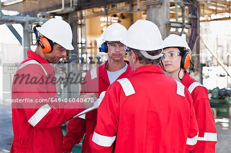 Workers talking at oil refinery