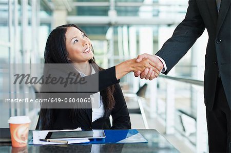 Business people shaking hands in cafe