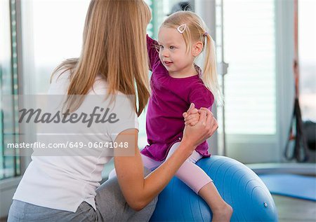 Girls playing with exercise ball in gym