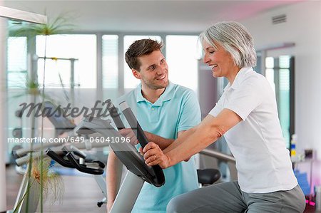 Trainer working with woman in gym Trainer working with woman in gym