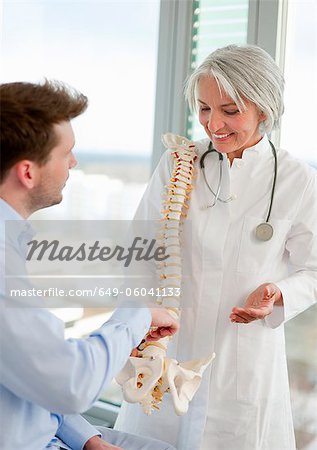 Doctor showing spine model to patient