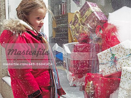 Girl admiring Christmas gifts in snow