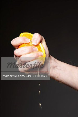 Hand squeezing orange