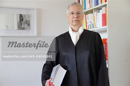 Lawyer holding text book in office