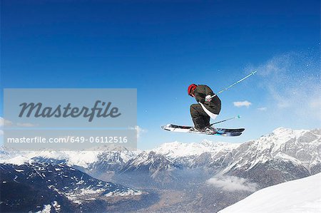 Skier jumping off snowy slope