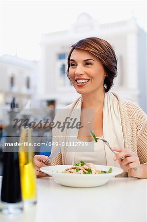 Woman eating at sidewalk cafe