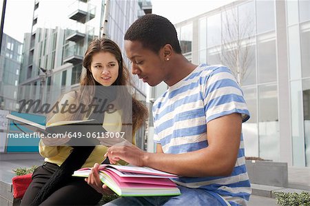 Students studying on city street