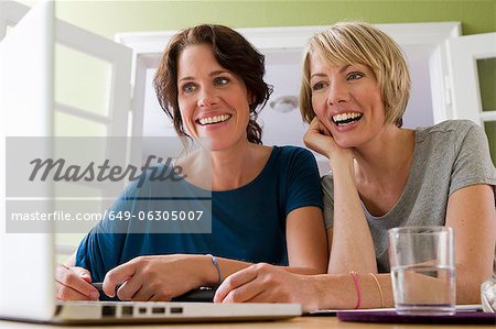 Women using laptop together Women using laptop together