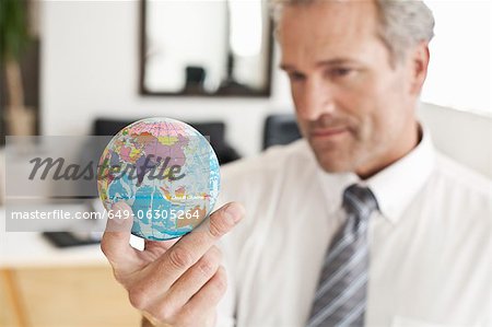 Businessman holding miniature globe