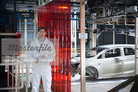 Portrait of worker inspecting car body in car factory