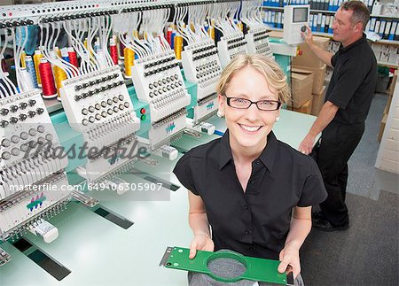 Worker examining fabric in factory