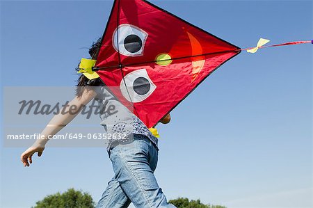 Girl playing with kite outdoors