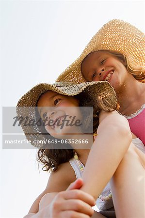 Smiling girls wearing sunhats outdoors