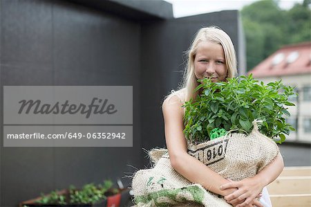 Teenage girl holding sack of plants