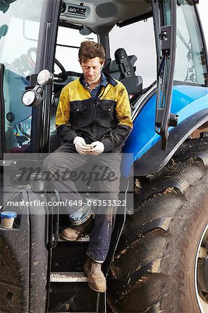 Farmer using cell phone on tractor