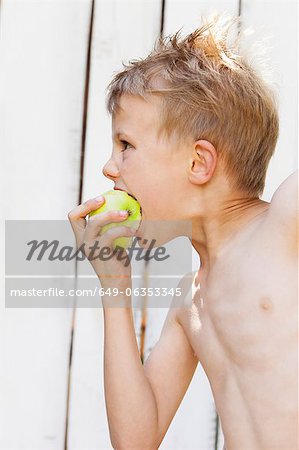 Close up of boy eating apple