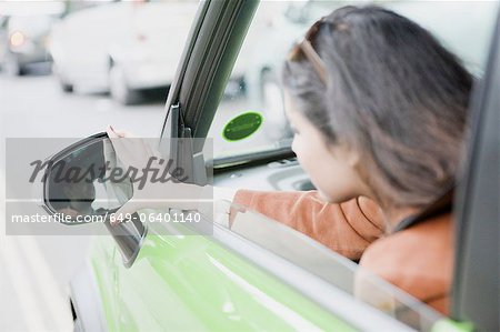 Woman adjusting side mirrors