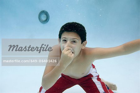 Boy holding nose underwater