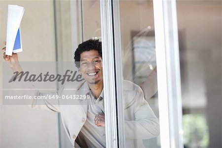 Businessman leaning in glass door
