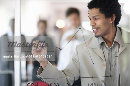 Businessman drawing graph on window Businessman drawing graph on window