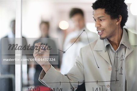 Businessman drawing graph on window