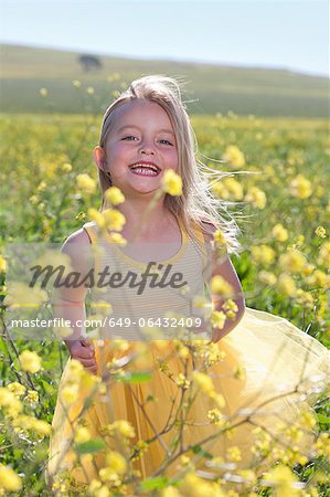 Smiling girl playing in field of flowers Smiling girl playing in field of flowers