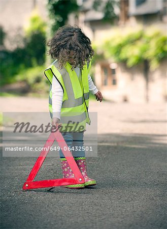 Girl playing traffic worker on rural road Girl playing traffic worker on rural road