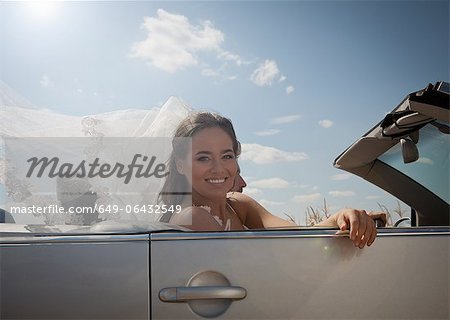 Newlywed couple driving in convertible