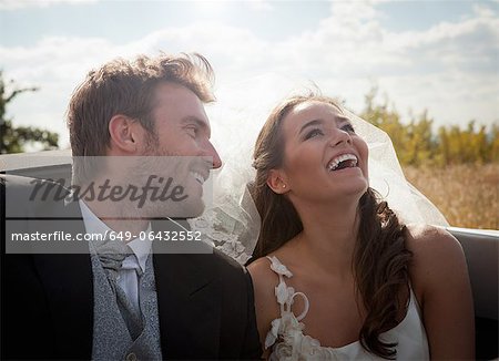 Newlywed couple sitting in convertible