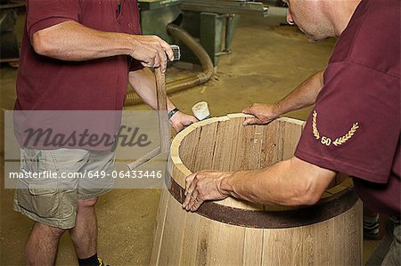 Workers hammering barrel in shop
