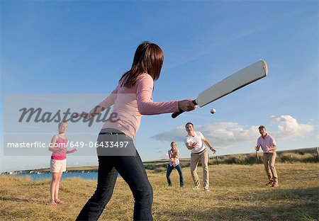 Family playing cricket together outdoors