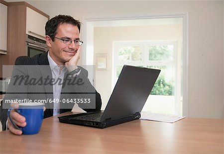 Businessman using laptop at breakfast