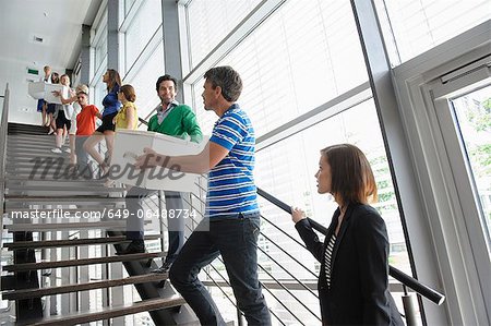 People passing boxes up stairs