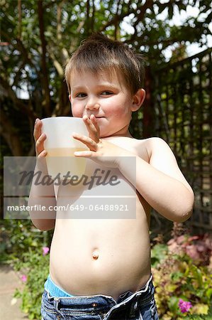 Boy drinking juice in garden