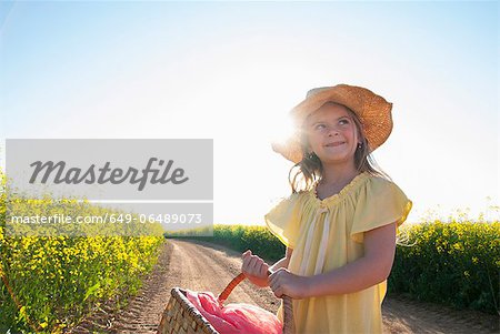 Girl carrying basket on dirt road