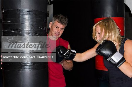 Boxer working with trainer in gym