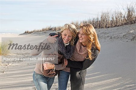 Smiling women walking on beach