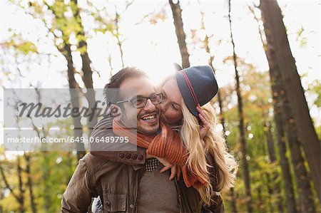 Smiling couple kissing in forest