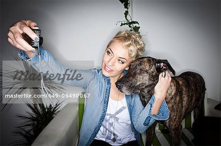 Smiling woman taking picture with dog