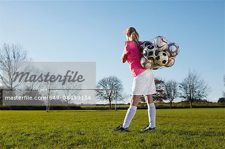 Football player carrying balls in field