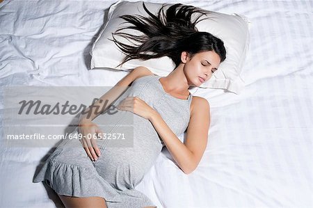 Pregnant woman sleeping in bed