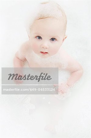 Baby girl sitting in bubble bath