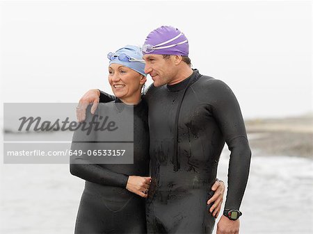 Divers smiling together on beach